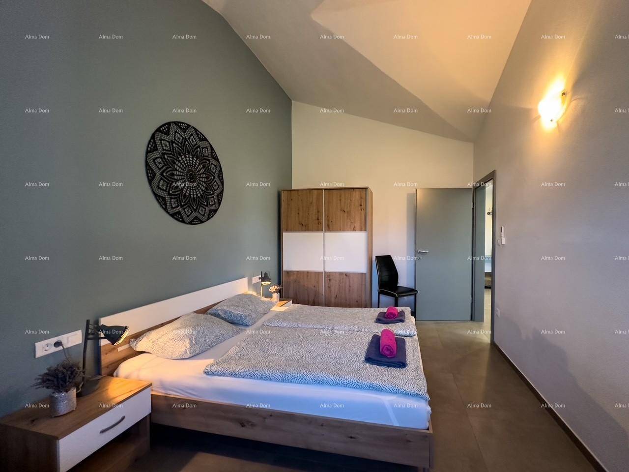 Gemütliches Schlafzimmer mit zwei Betten, Holzschrank und blauer Akzentwand.