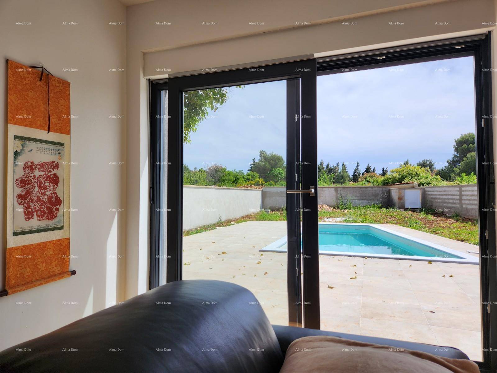 Blick aus dem Wohnzimmer durch die große Glasschiebetür auf den sonnigen Poolbereich im Freien.