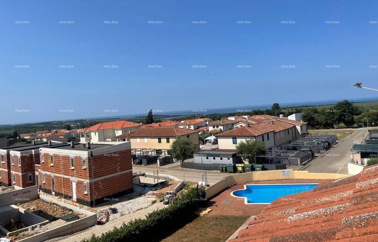 Weitläufige Ansicht einer Wohnsiedlung mit mehreren Häusern, einem Pool und Blick auf die Landschaft.