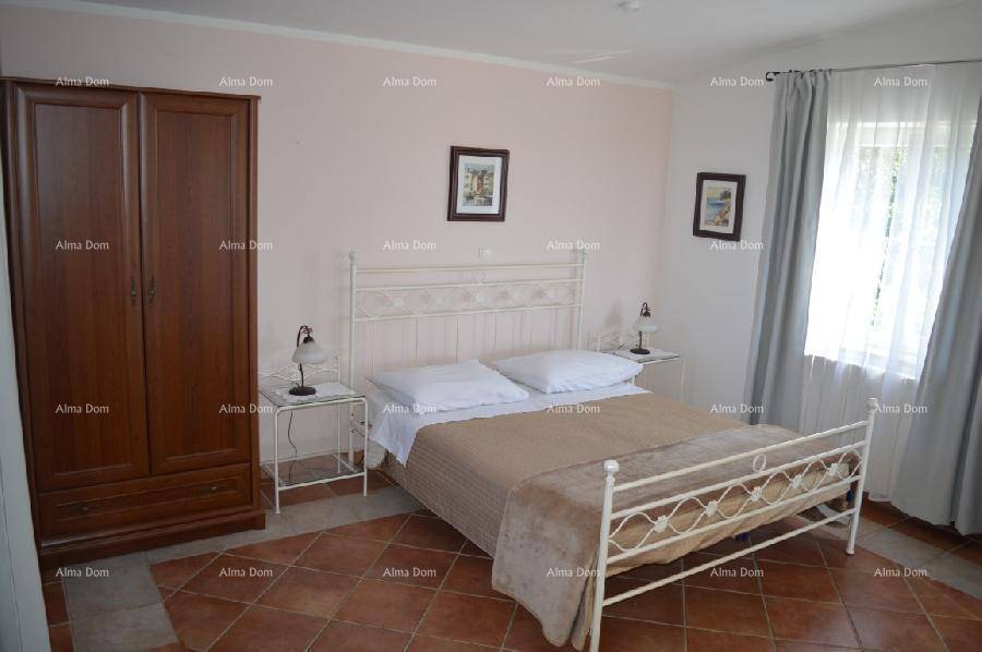 Geräumiges Schlafzimmer mit schmiedeeisernem Doppelbett, Holzschrank und Fliesenboden.