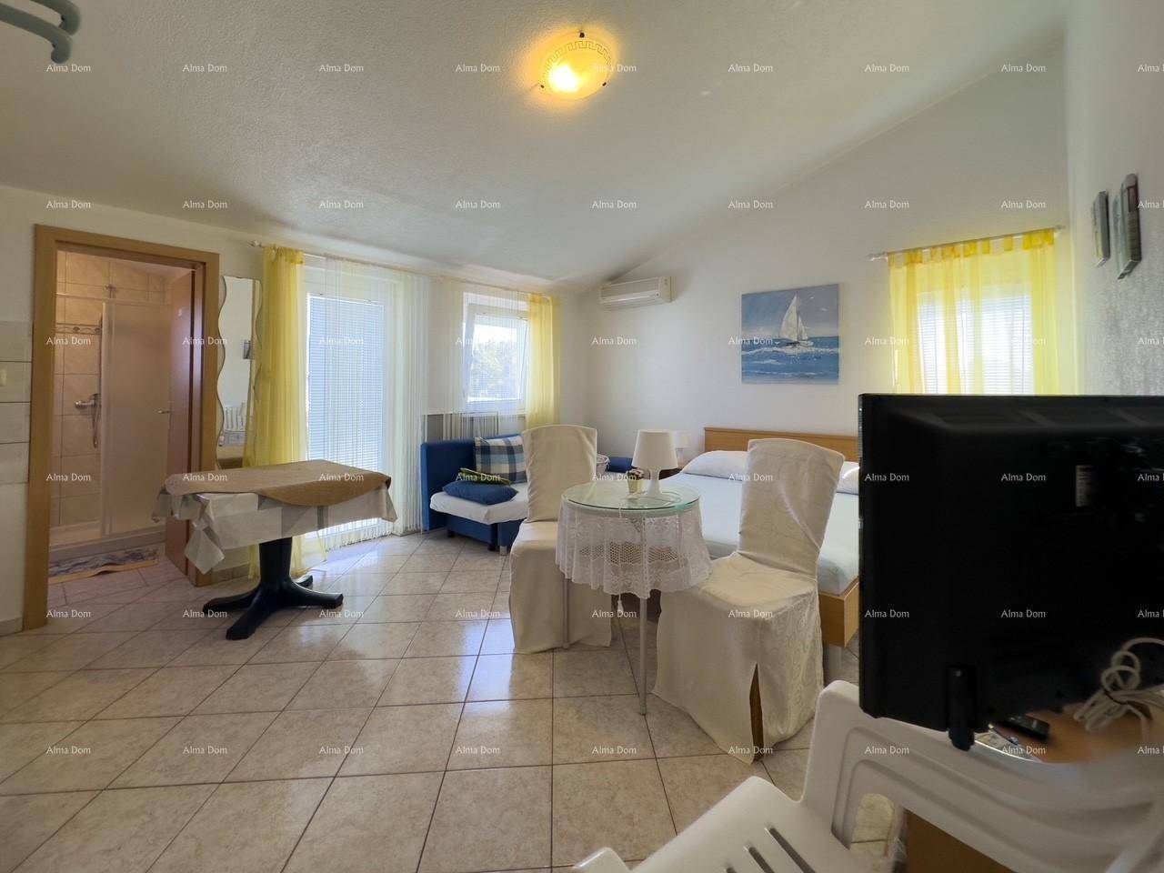 Helles Schlafzimmer mit Fliesenboden, TV und direktem Zugang zum Badezimmer.