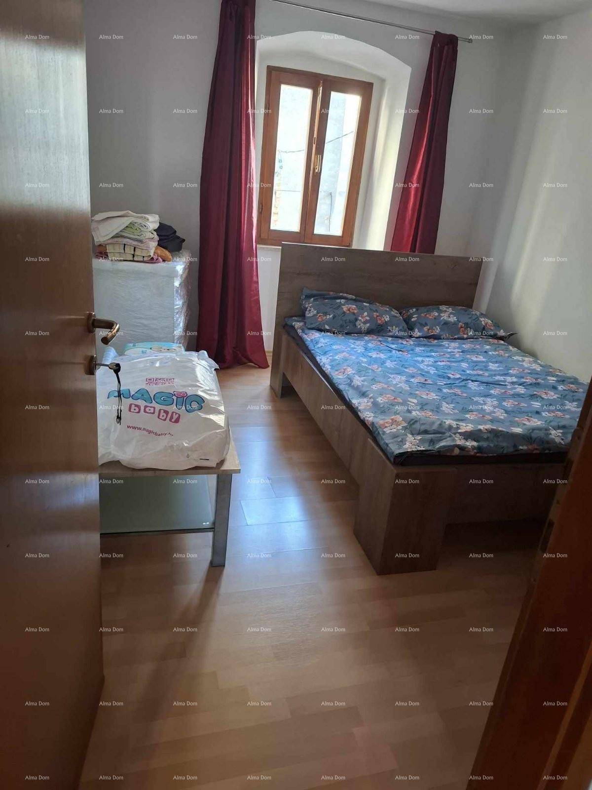 Helles Schlafzimmer mit Doppelbett und Laminatboden, gut beleuchtet durch das Fenster.