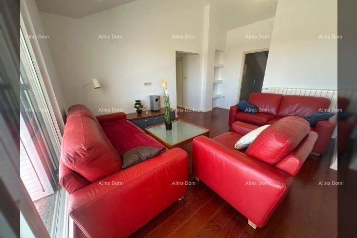 Wohnzimmer mit roten Ledersofas, Holzboden und Zugang zu einem Balkon oder einer Terrasse.