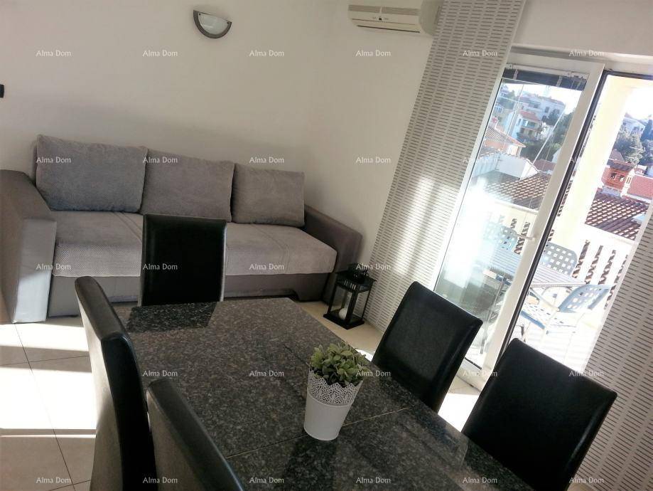 Heller Wohn- und Essbereich mit Sofa, Esstisch und Zugang zu einem Balkon.