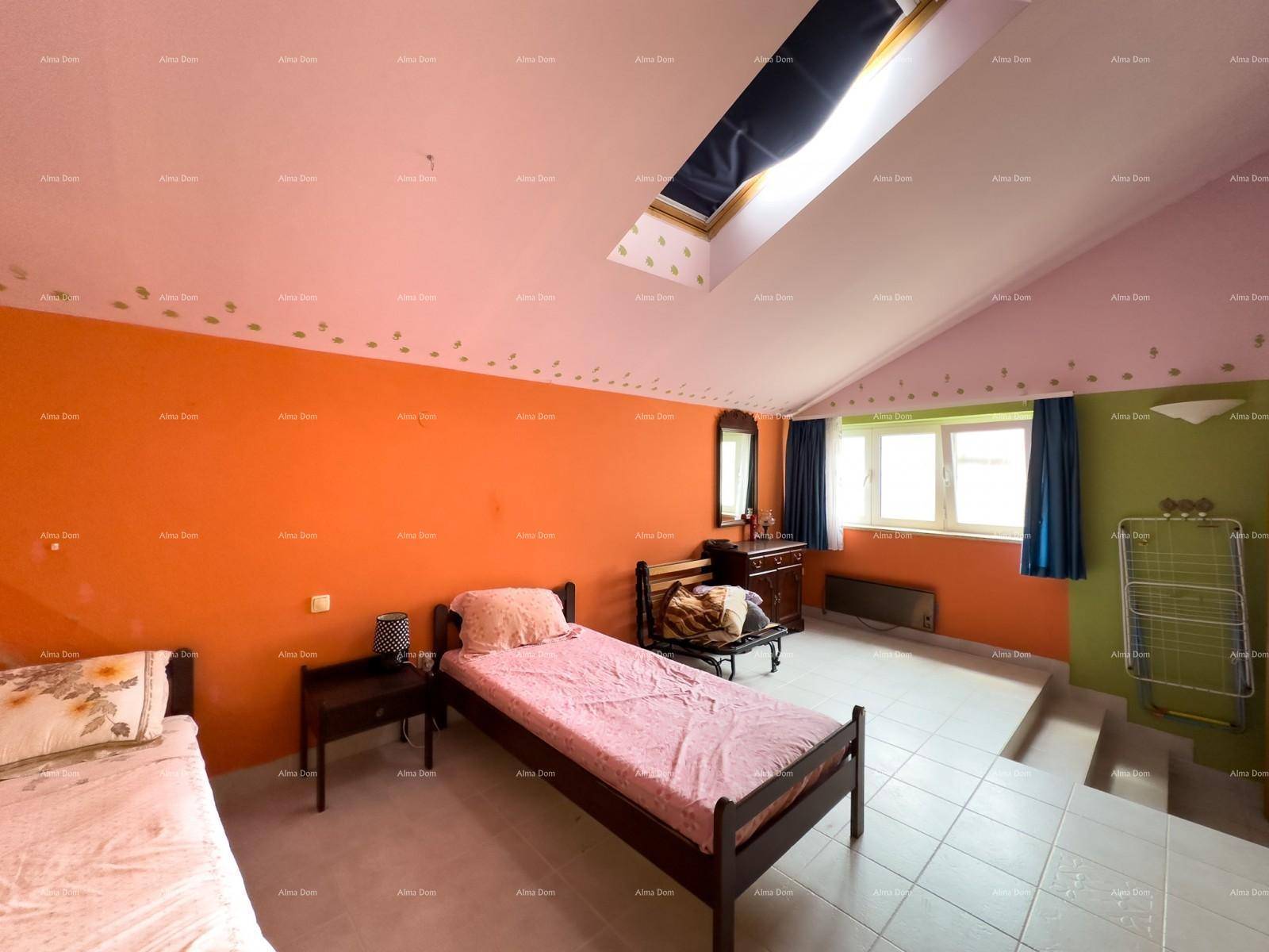 Geräumiges Schlafzimmer im Dachgeschoss mit schrägen Wänden, Dachfenster und bunten Akzenten.