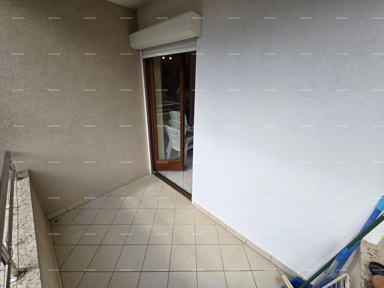 Balkon mit Fliesenboden und Rollladen über der Balkontür, Blick in den Innenbereich.