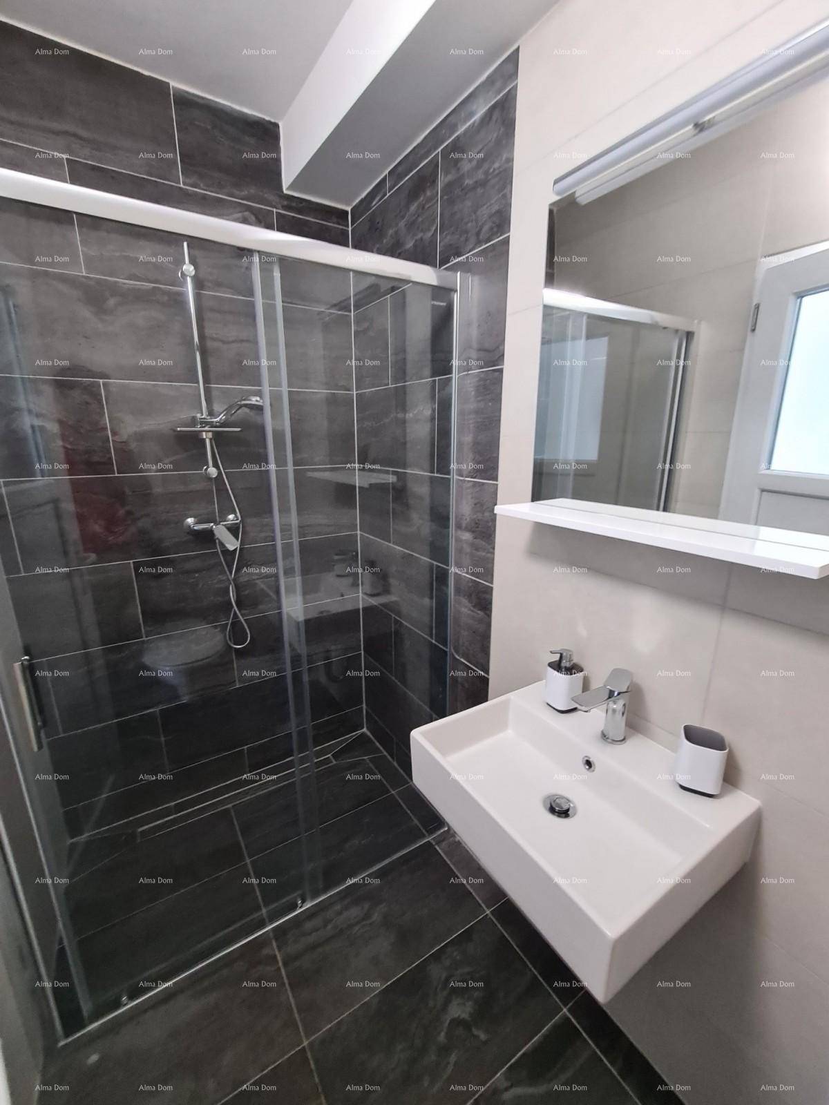 Modernes Badezimmer mit Duschkabine, Waschbecken und Spiegel, in Grautönen gefliest.