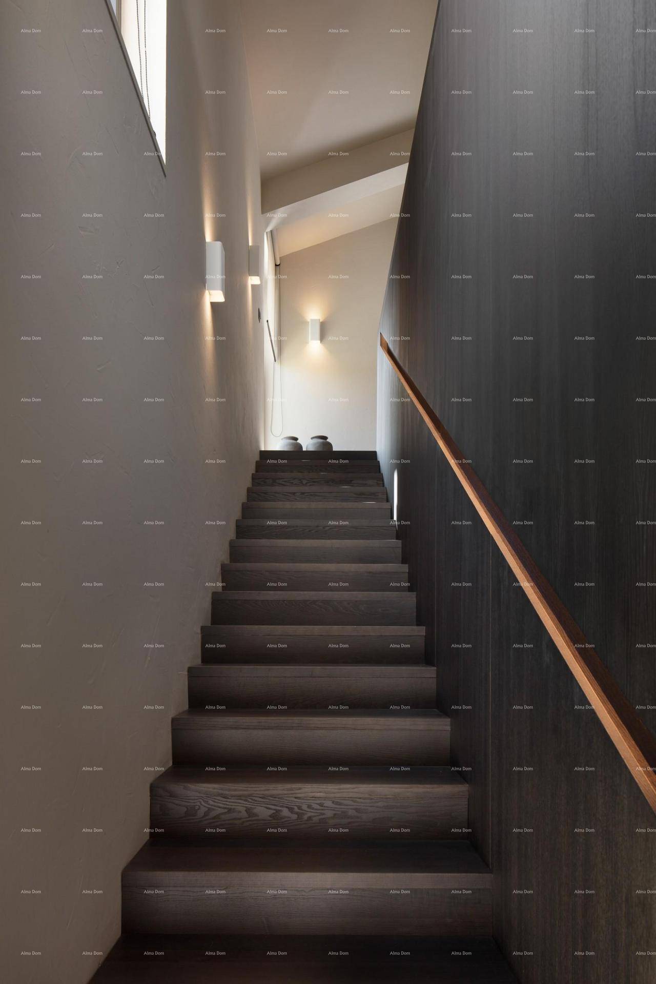 Elegante Holztreppe mit dunklen Stufen und modernem Handlauf in einem hellen Flur.