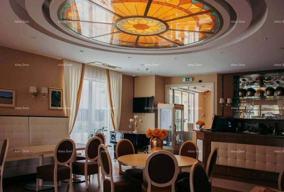 Eleganter Essbereich mit kunstvoller Deckenbeleuchtung, bequemen Stühlen und einer stilvollen Bar im Hintergrund.