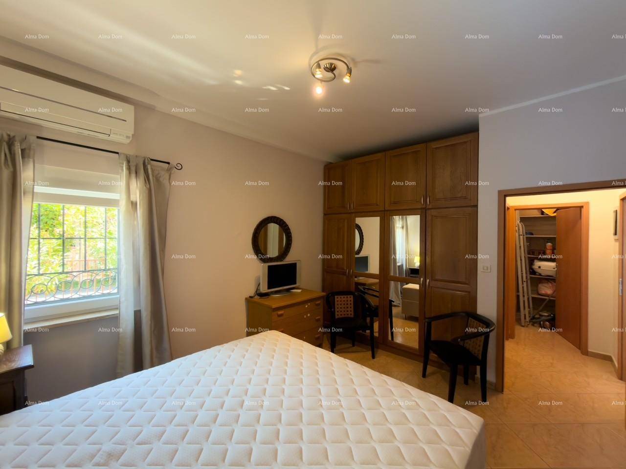 Schlafzimmer mit großem Kleiderschrank, Doppelbett und Fenster.