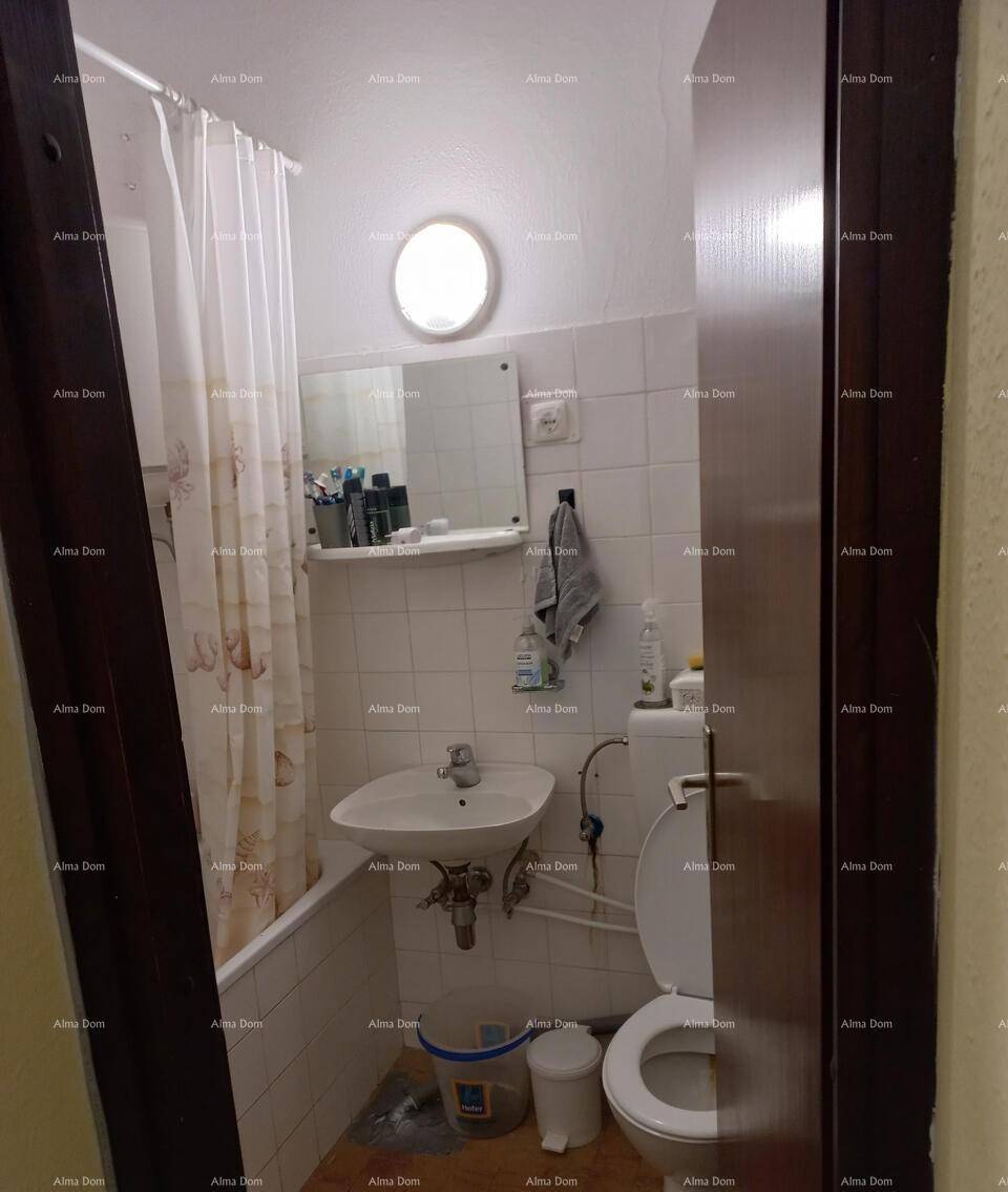 Kleines Badezimmer mit Badewanne, Duschvorhang, Waschbecken und Toilette, funktional eingerichtet.