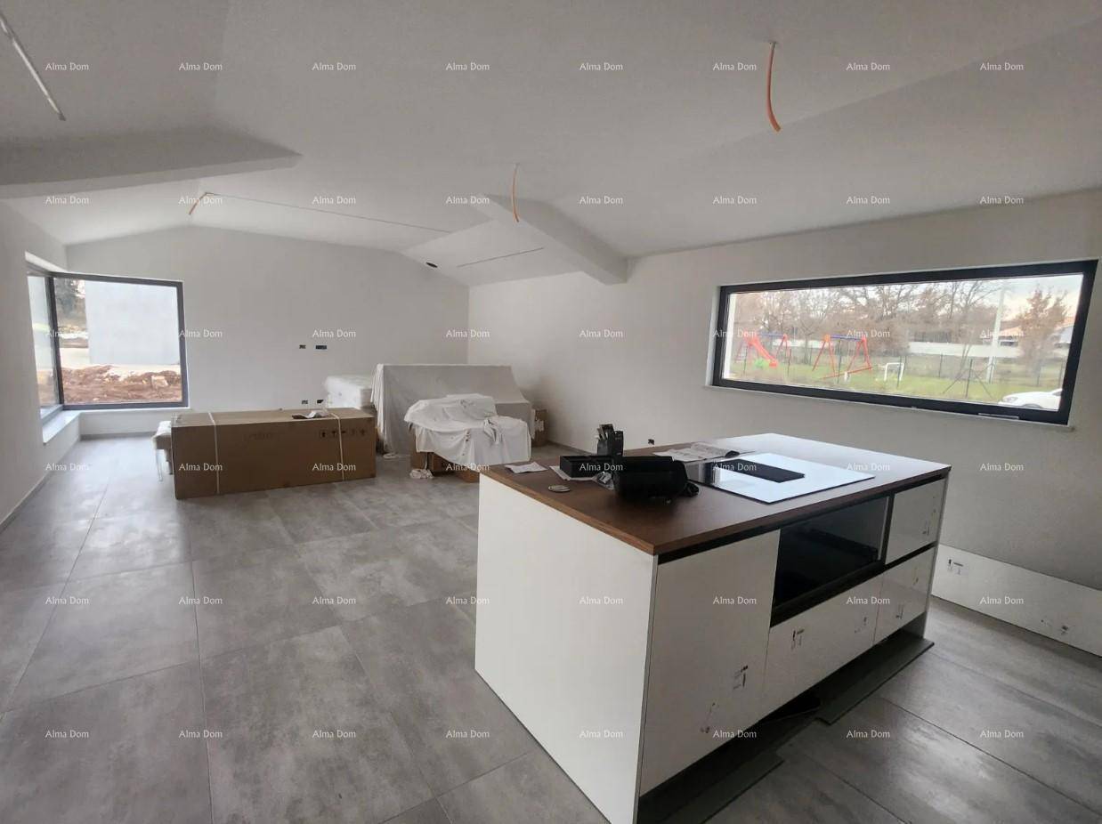 Heller offener Wohnbereich mit Kücheninsel und großen Fenstern, bietet viel natürliches Licht.