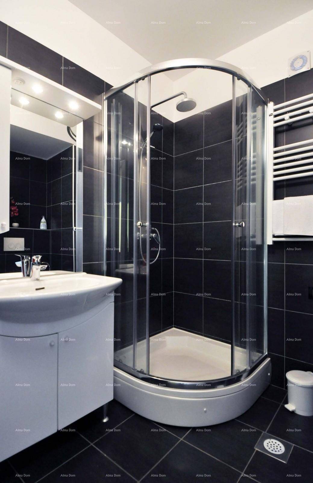Modernes Badezimmer mit dunklen Fliesen, Duschkabine und beheiztem Handtuchhalter.