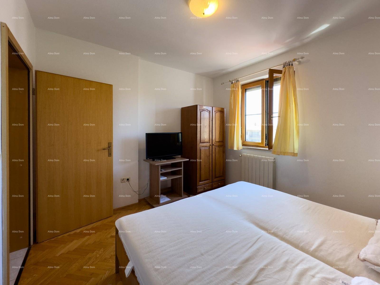 Schlafzimmer mit Doppelbett, Holzschrank und Fernseher, mit Parkettboden ausgestattet.