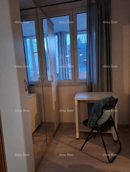 Kleiner Raum mit Fenster, Spiegelschrank und einem Tisch, nutzbar als Schlaf- oder Arbeitsbereich.