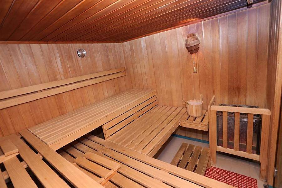 Traditionelle Sauna mit Holzbänken und Holzverkleidung, bereit zur Entspannung.