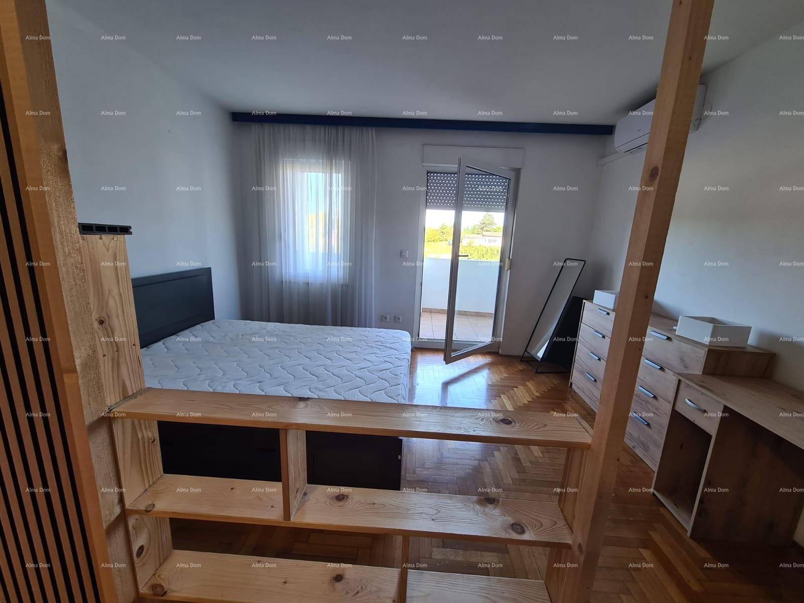 Schlafzimmer mit Bett, Kommode und Zugang zu einem Balkon.