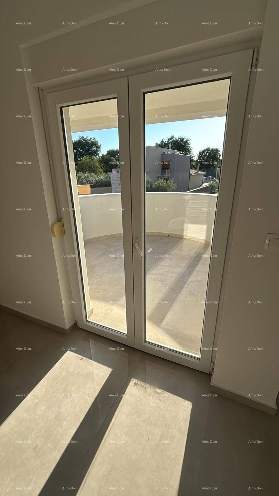 Große Fenstertüren lassen viel Sonnenlicht auf den glänzenden Fliesenboden fallen.