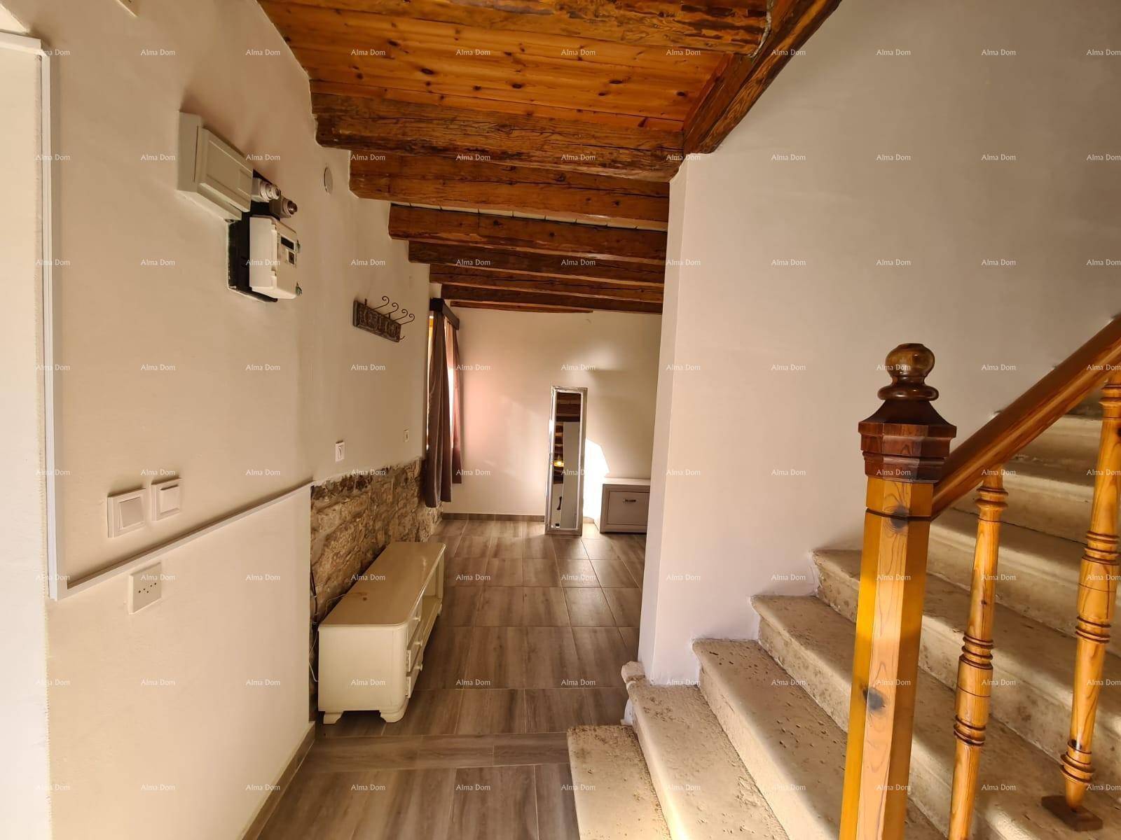 Eingangsbereich mit Steintreppe, freiliegender Steinwand und rustikaler Holzbalkendecke.