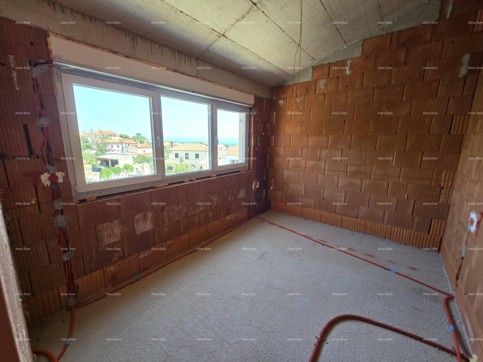 Schlafzimmer im Rohbau mit großem Fenster und weitem Blick auf die Umgebung.