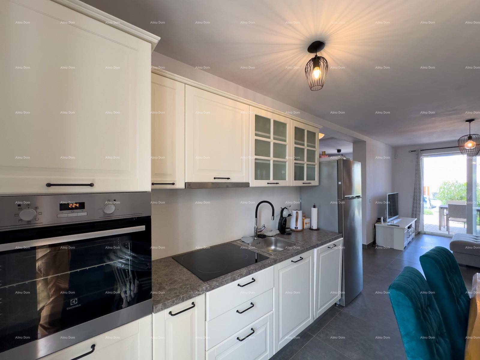 Moderne Einbauküche mit Backofen, Kochfeld und weißen Schränken in offenem Wohnkonzept.