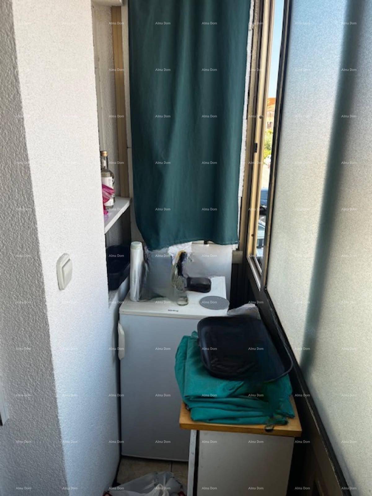 Schmaler, verglaster Balkon, genutzt als praktischer Abstellraum mit Kühlschrank.