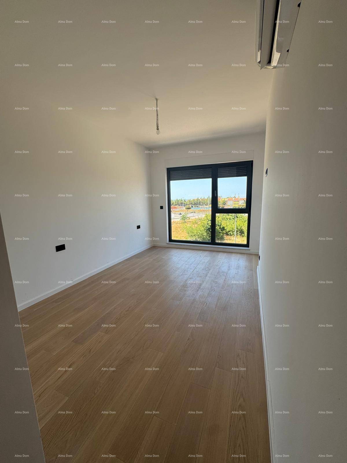 Helles Zimmer mit Holzboden, großen Fenstern und Blick ins Grüne.
