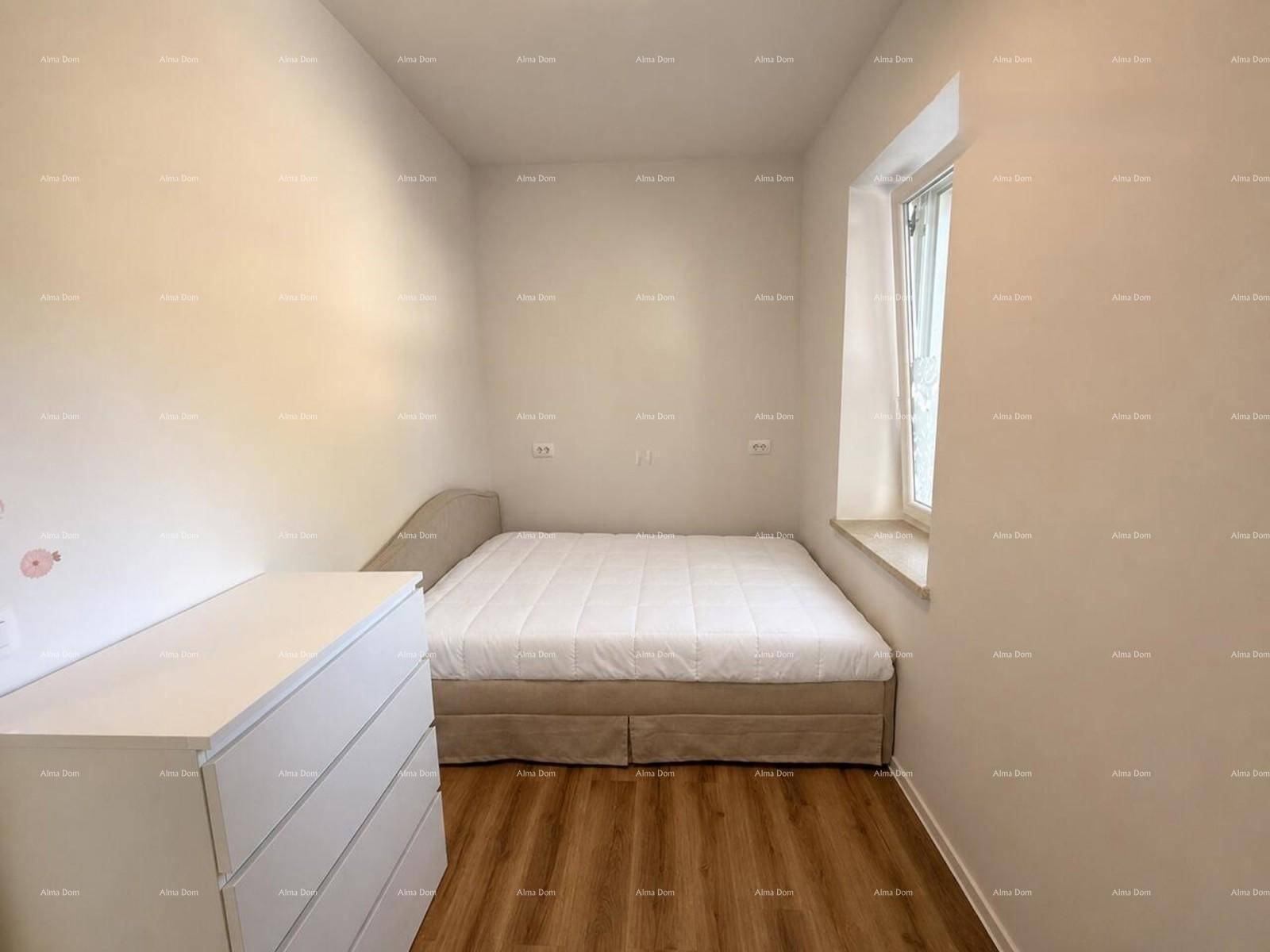 Helles Schlafzimmer mit Doppelbett, weißer Kommode und Holzboden.