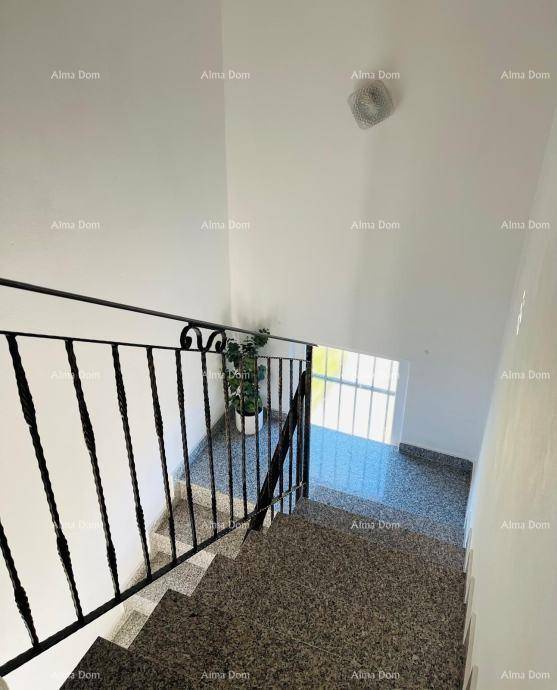Treppenhaus mit Granitstufen und schmiedeeisernem Geländer, das die Etagen verbindet.