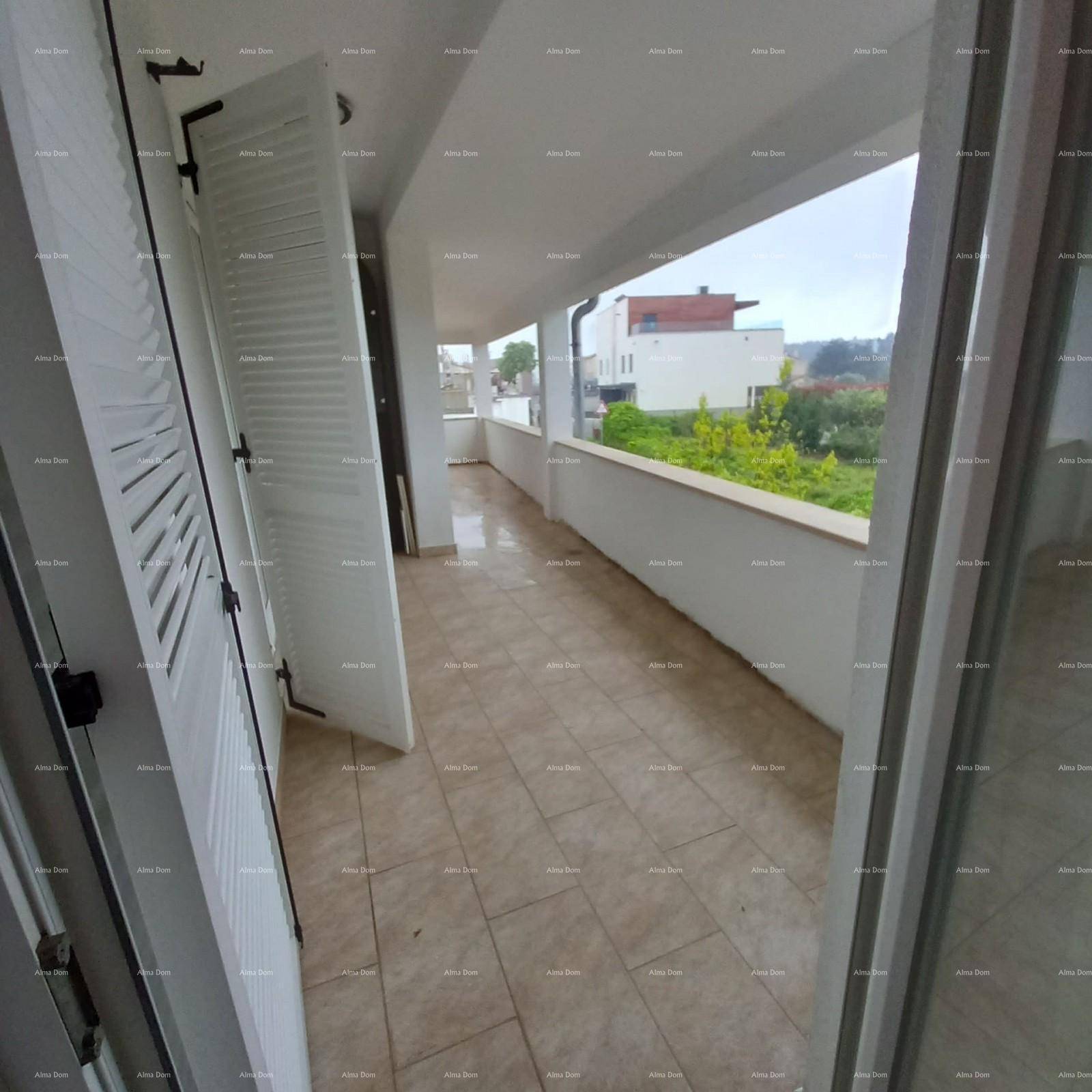 Langer Balkon mit Fliesenboden und geöffneten Fensterläden, bietet einen Blick auf die Umgebung.