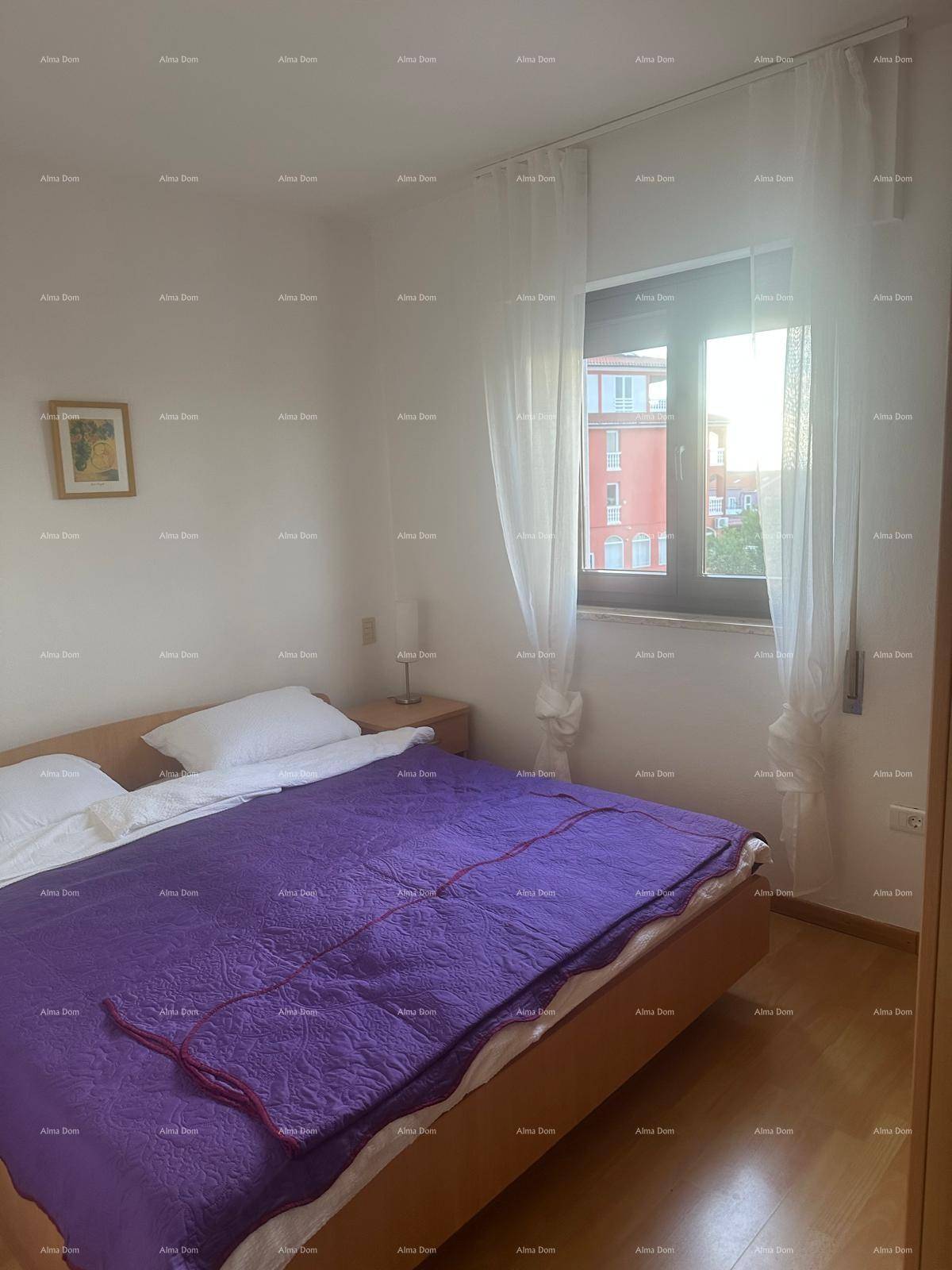 Gemütliches Schlafzimmer mit Holzboden, Doppelbett und Fenster mit hellen Vorhängen.