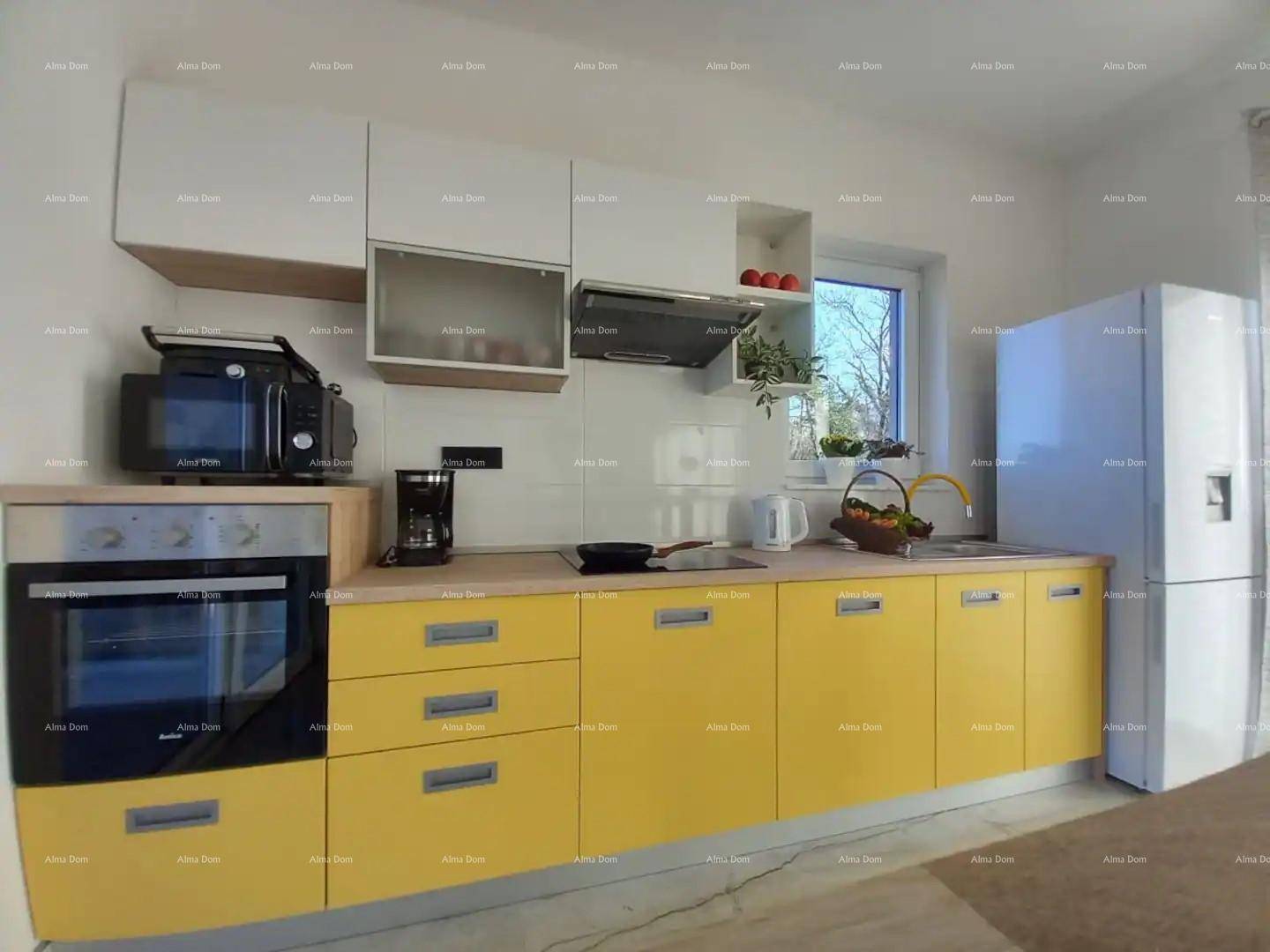 Moderne Einbauküche mit gelben Fronten, weißen Oberschränken und Fenster.