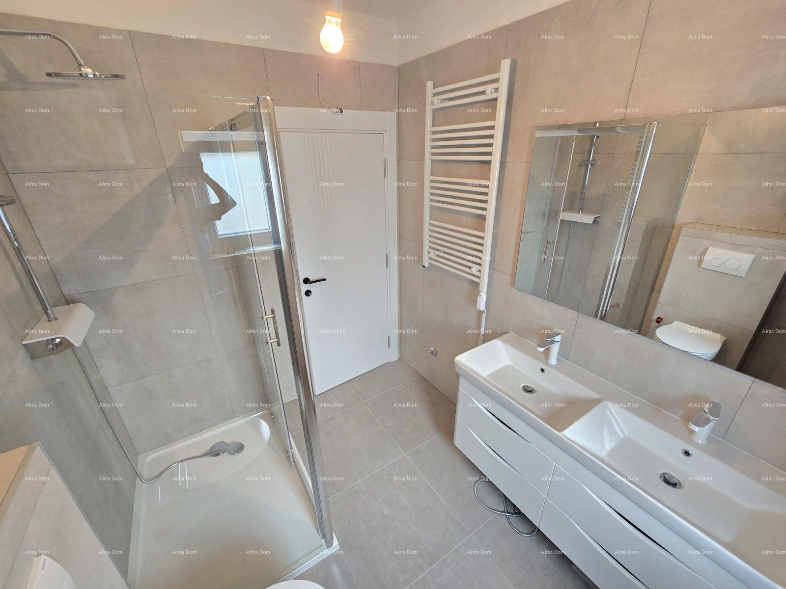Modernes Badezimmer mit Duschkabine, Doppelwaschbecken und beheiztem Handtuchhalter.