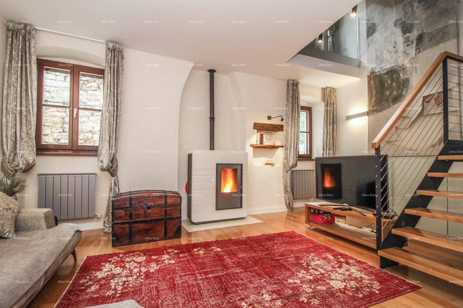 Gemütliches Wohnzimmer mit Kaminofen, Holzboden und einer bequemen Couch für entspannte Abende.
