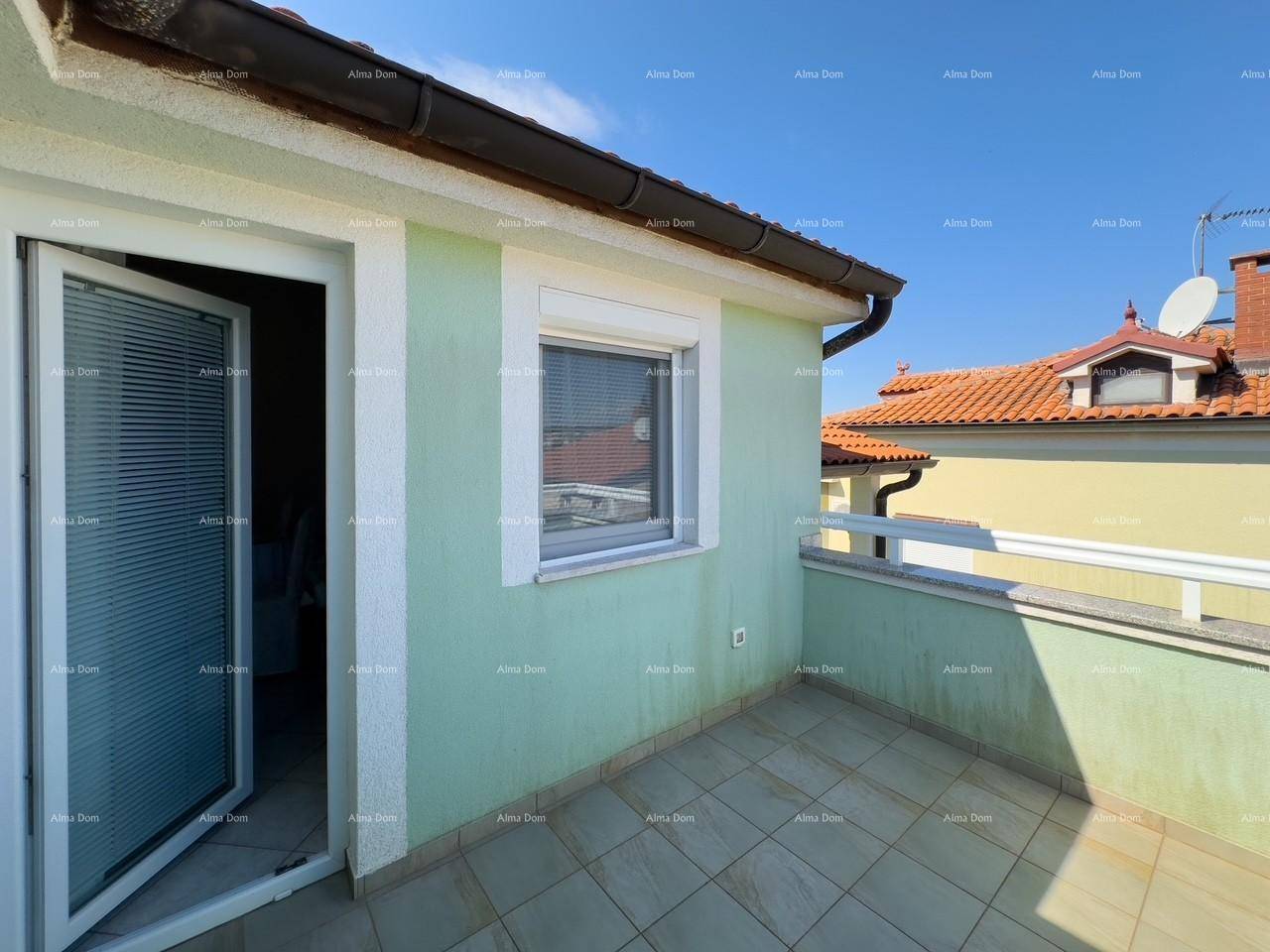 Heller Balkon mit Fliesenboden und Ausblick auf die umliegenden Dächer und Häuser.