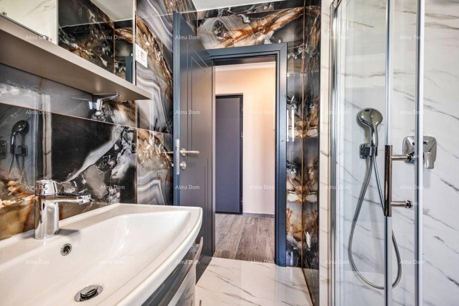 Modernes Badezimmer mit dunklen Marmorfliesen, Duschkabine und stilvollem Waschbecken.