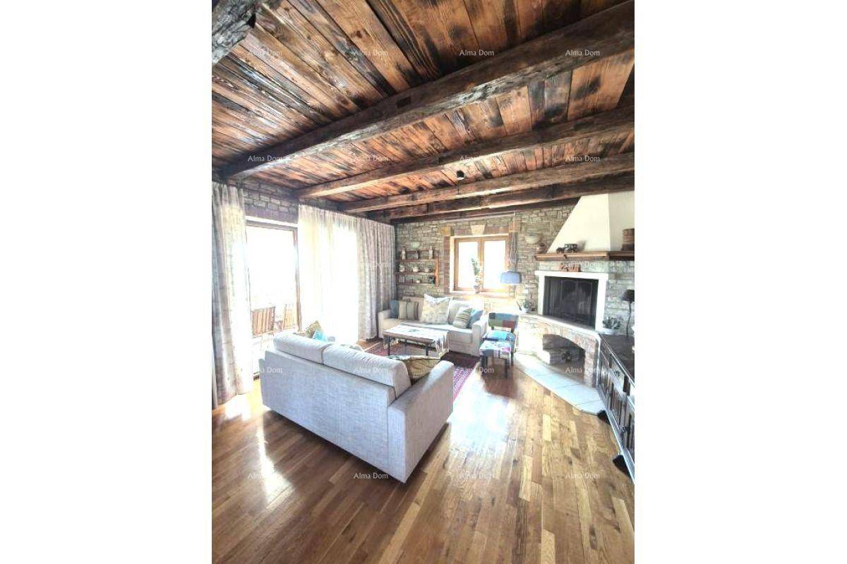 Geräumiges Wohnzimmer mit Holzbalkendecke, Kamin und Holzboden, hell und einladend.