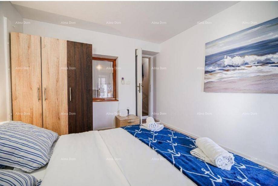 Schlafzimmer mit Holzboden, großem Bett und einem Kunstwerk an der Wand.