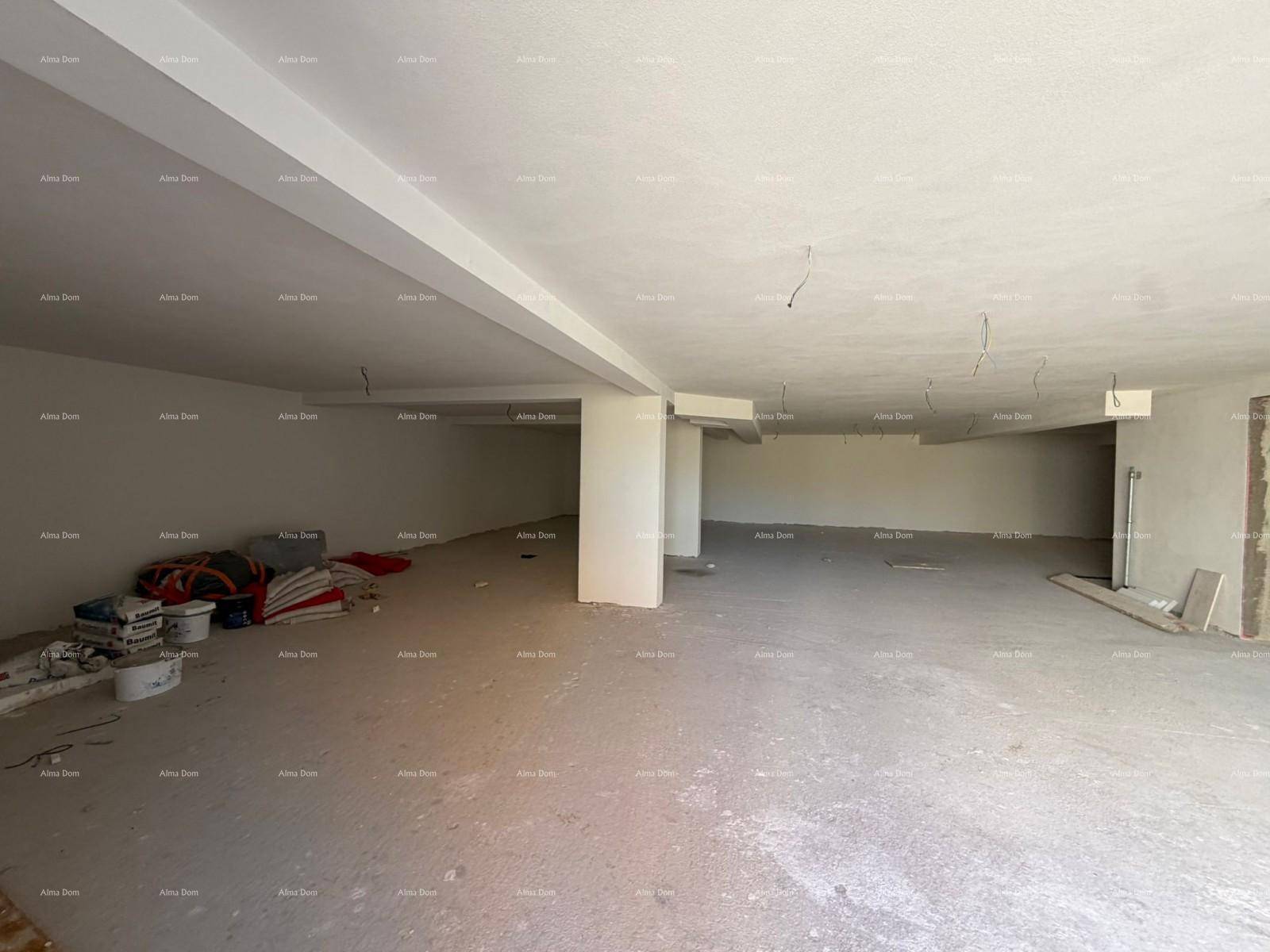 Großer, leerer Raum im Rohbau mit Betonboden und sichtbaren Säulen, bereit für den Innenausbau.