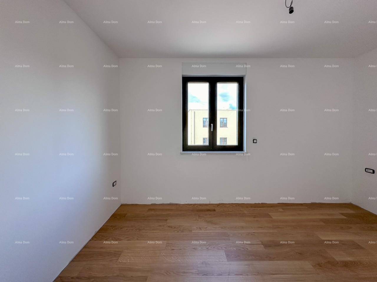 Helles Schlafzimmer im Rohbau mit Holzboden und einem Fenster.