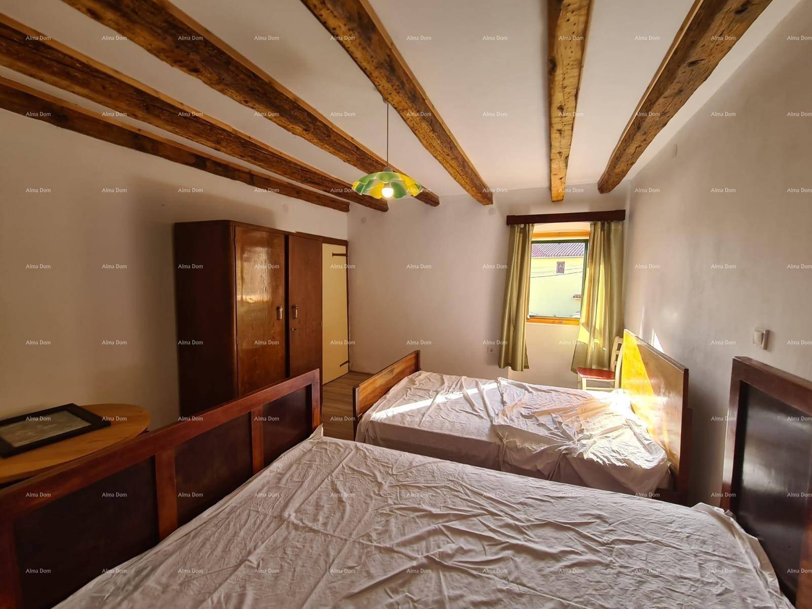 Schlafzimmer mit zwei Betten, Holzbalkendecke und einem Kleiderschrank, ideal für Gäste oder Kinder.