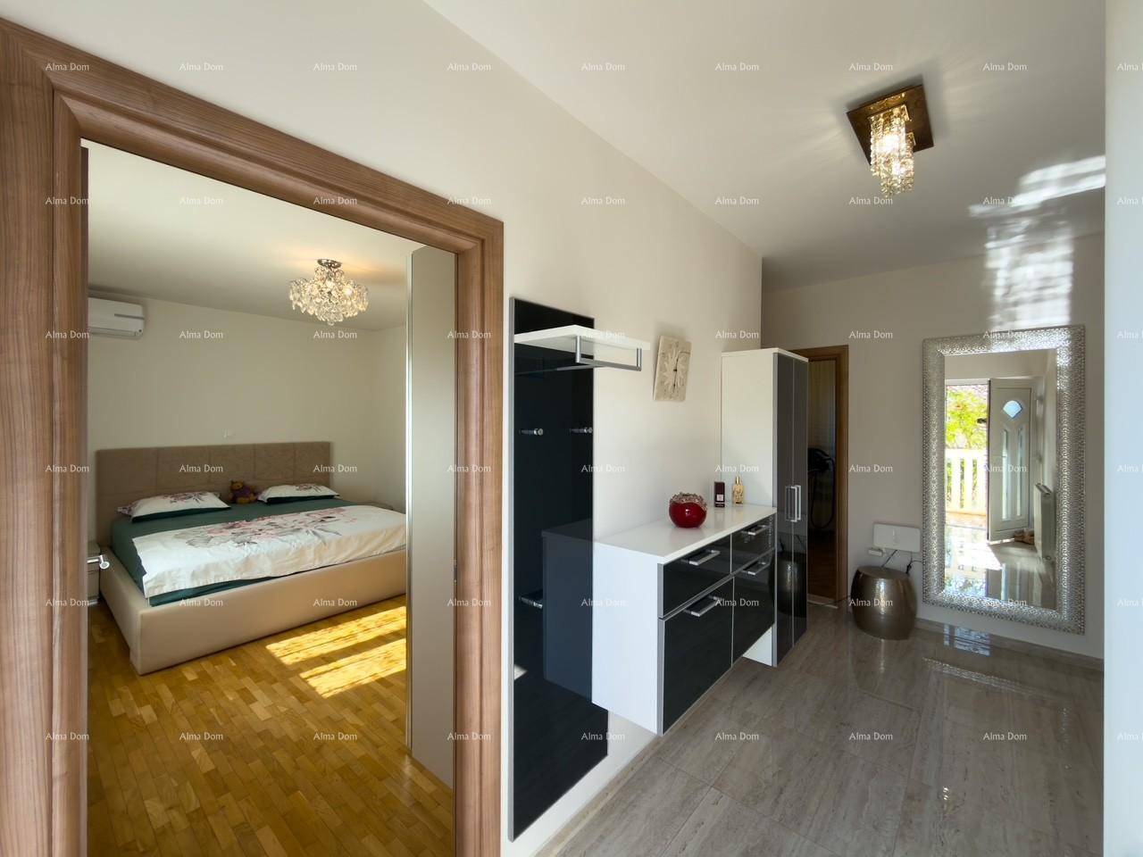 Heller Flur mit modernen Möbeln und Zugang zu einem Schlafzimmer mit Holzboden.