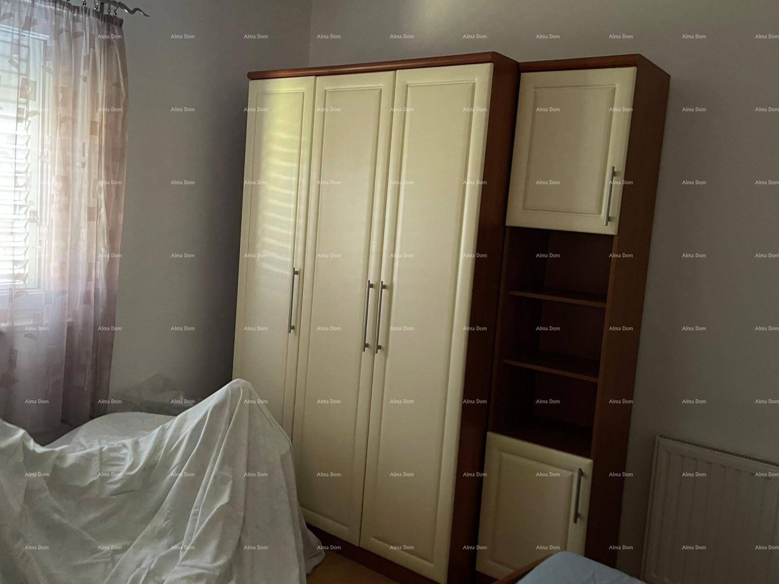 Schlafzimmer mit einem großen Kleiderschrank und einem Fenster, das für ausreichend Tageslicht sorgt.