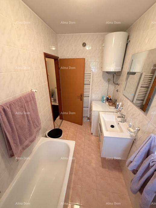 Funktionales Badezimmer mit Badewanne, Waschbecken, WC und beheiztem Handtuchhalter.
