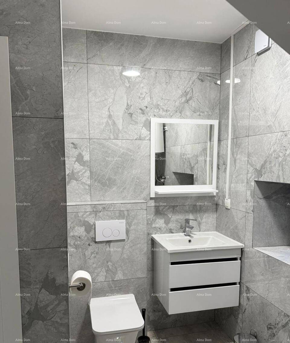Modernes WC mit wandhängender Toilette, Waschtisch und Spiegelschrank in grauen Fliesen.