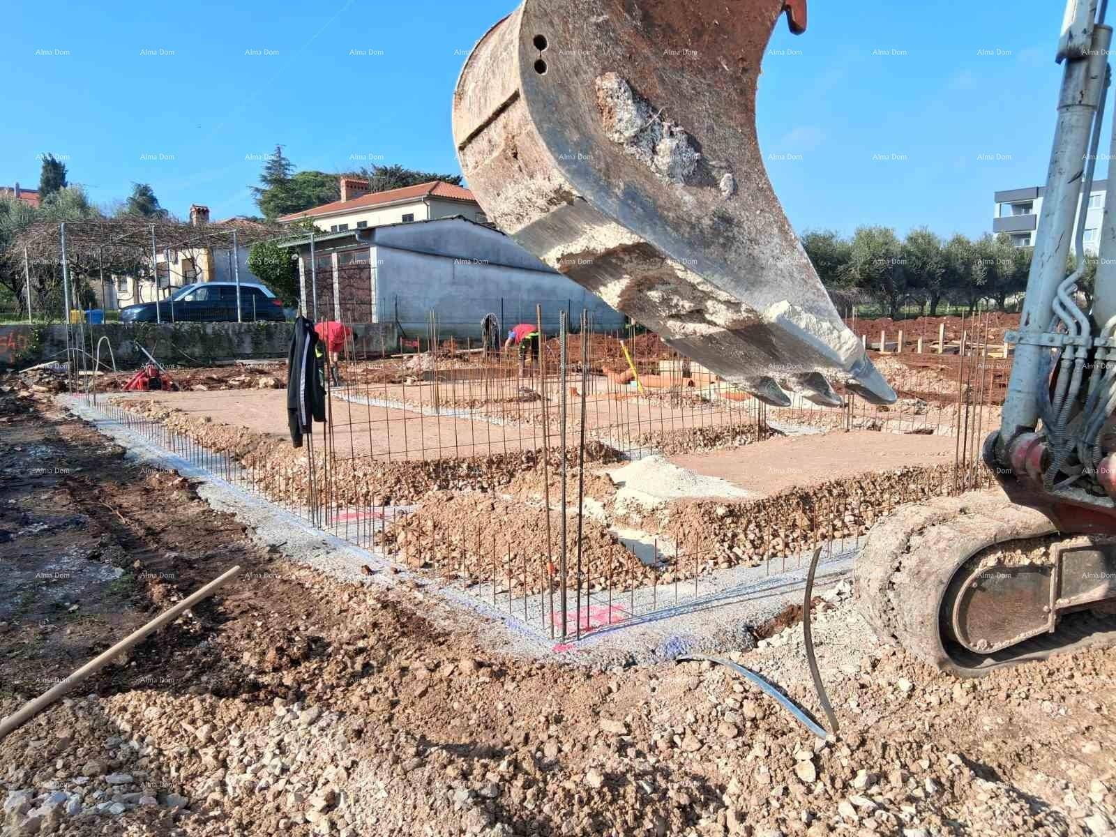 Detailansicht der Baustelle mit Fundamentarbeiten und Bagger im Vordergrund.