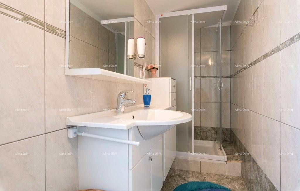 Helles Badezimmer mit Duschkabine, modernem Waschbecken und Spiegel, umgeben von hellen Wandfliesen.