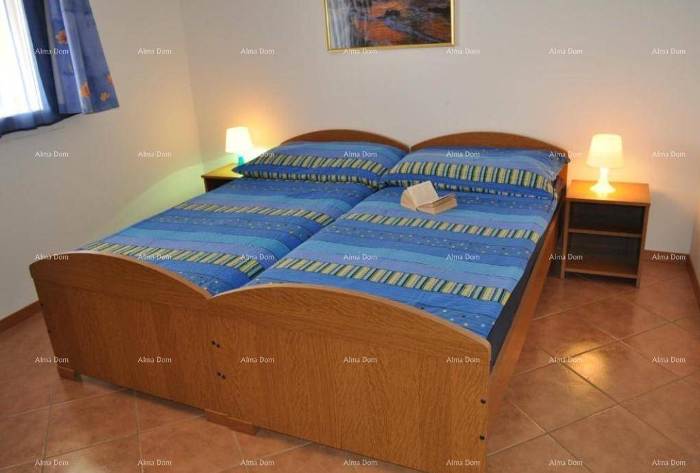 Schlafzimmer mit zwei Einzelbetten, Nachttischen und Fliesenboden.