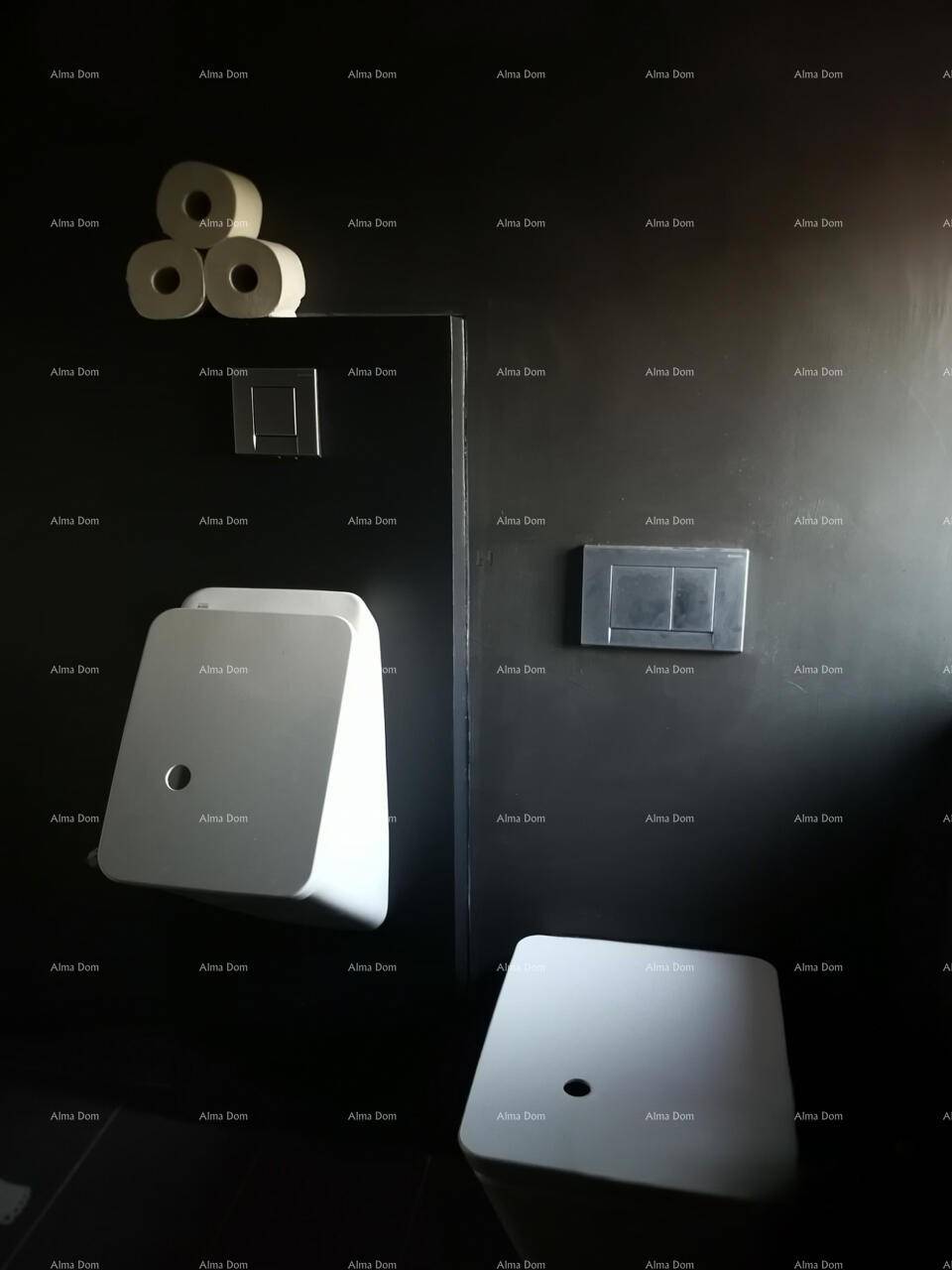 Modernes WC mit dunklen Wänden, Urinal und minimalistischem Design.