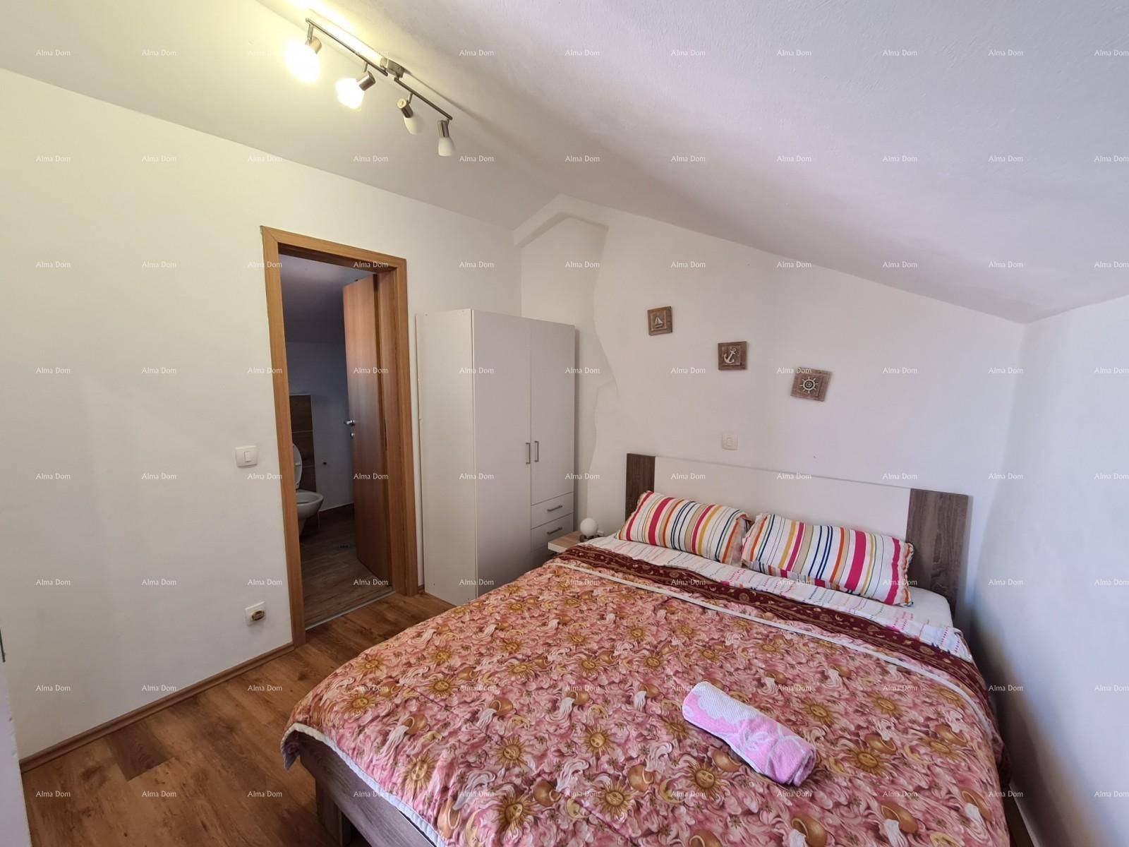 Gemütliches Schlafzimmer mit Doppelbett, Holzboden und Dachschräge.